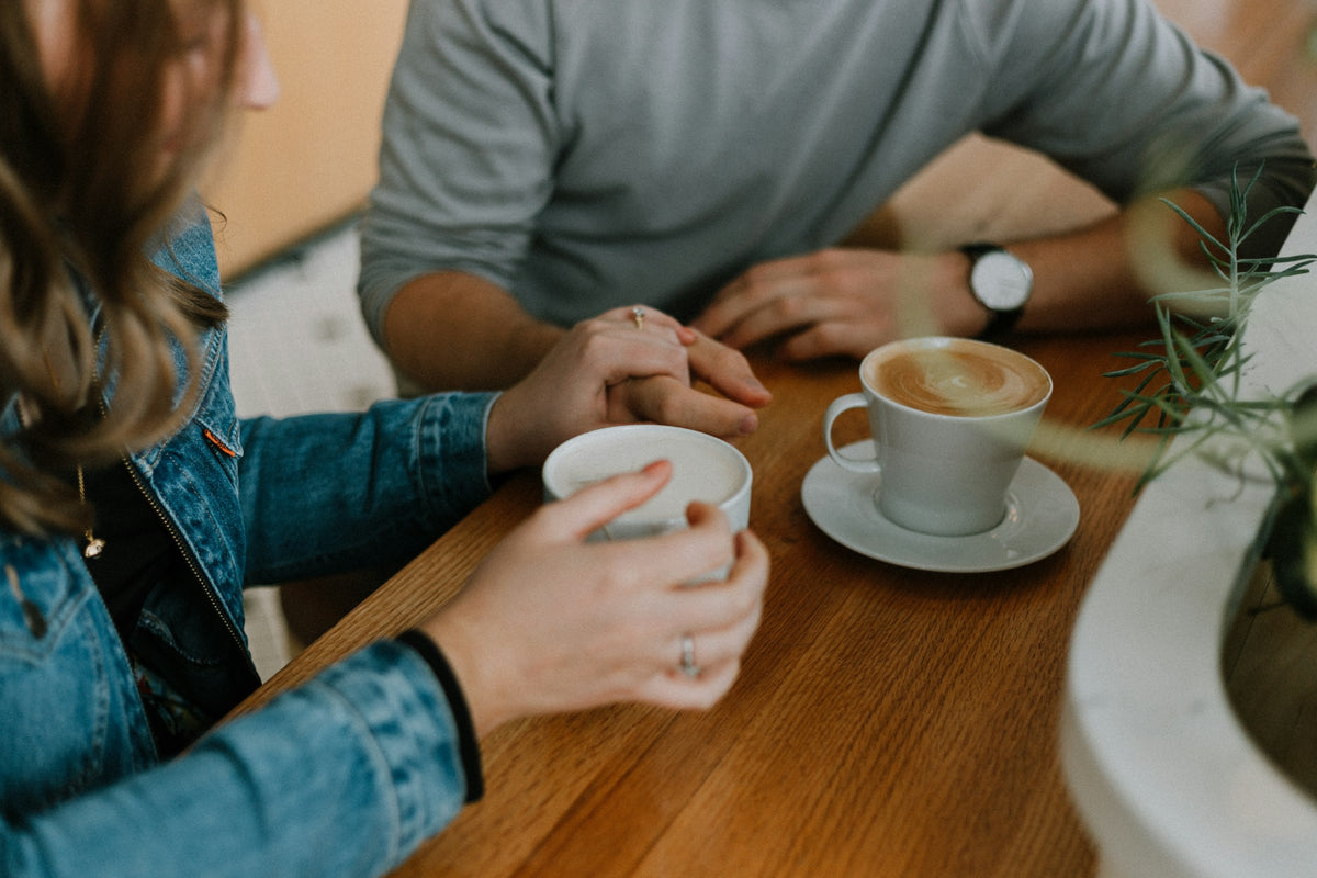 Paar beim ersten Date im Café mit zwei Tassen Kaffee